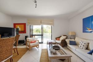セジンブラにあるBmyGuest - Sesimbra Palames Beach & Pool Apartmentのソファとテーブルのあるリビングルーム