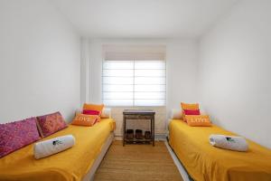 セジンブラにあるBmyGuest - Sesimbra Palames Beach & Pool Apartmentの窓付きの客室で、黄色のベッド2台が備わります。 +18枚の写真