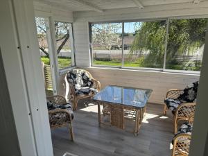 a screened in porch with chairs and a table at Glommen in Falkenberg