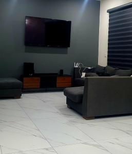 Una sala de estar con sofás y un televisor de pantalla plana. en Villa Beatriz, en Ciudad de México
