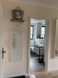 a bathroom with a door leading into a kitchen at Zum Schwedenblick in Zingst +18 photos