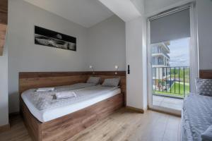 a bedroom with a bed and a large window at Apartamenty Galicja Zator in Zator