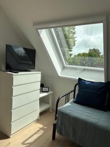 a bedroom with a window and a bed and a dresser at Zum Schwedenblick in Zingst