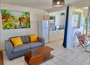 a living room with a couch and a table at Suite Caraïbes, vue mer in Le Diamant