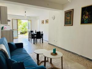 a living room with a blue couch and a table at Apartment in Villa under Grand Palm Tree & Garden in Porto Alabe