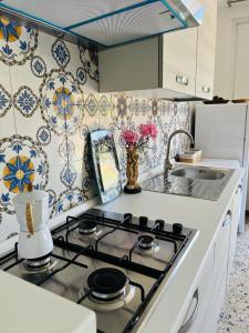 a kitchen with a stove top and a sink at Apartment in Villa under Grand Palm Tree & Garden in Porto Alabe +28 photos