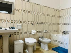 a bathroom with a toilet and a sink and a tub at Apartment in Villa under Grand Palm Tree & Garden in Porto Alabe
