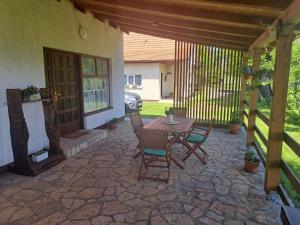 a patio with a table and chairs and a door at Apartman Mia in Perušić