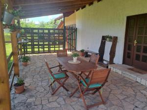 a wooden table and chairs on a patio at Apartman Mia in Perušić