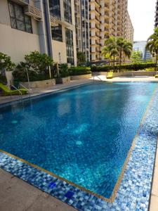 a large blue swimming pool in a building at Stylish New Studio at McKinley Hill BGC Free Netflix in Manila