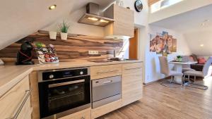 a kitchen with wooden cabinets and a stove at Ferienwohnungen Wolf - Wohnung "Breitenberg" 2,5 Zimmer mit Bergblick in Pfronten