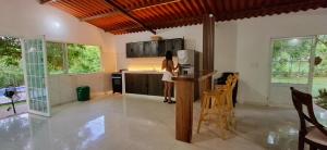 a woman standing in the kitchen of a house at Cabaña Villa Hellen in Santa Marta
