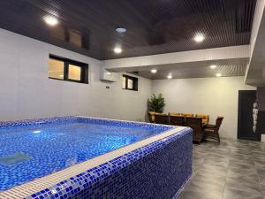 a swimming pool in a room with a table and chairs at Porto Bello Hotel in Tashkent