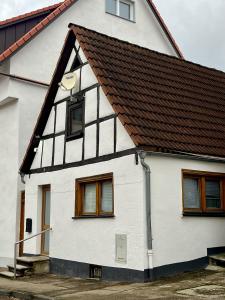 a white house with a brown roof at Stadtperle Apartment in Neresheim +4 photos