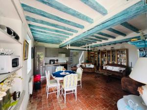 a dining room with a table and chairs in a room at Le Gîte De L'Ouche Charlot in Maux