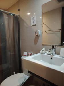 a bathroom with a sink and a toilet and a shower at Stylish New Studio at McKinley Hill BGC Free Netflix in Manila