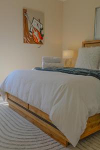 a bedroom with a large bed with white sheets at Golf Estate Living 1BR Apartment in Jackal Creek in Roodepoort