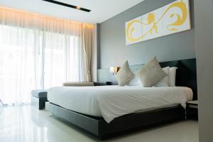 a bedroom with a large bed and a large window at Beachfront 1 BR Hotel Infinity Pool Patong Phuket in Patong Beach