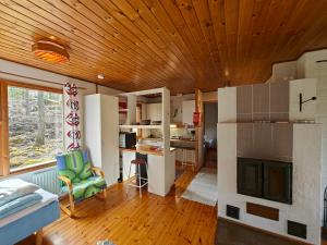 a room with a living room and a kitchen with a fireplace at Pyhtään Vuokramökit in Tuuski