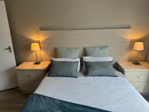 ein Schlafzimmer mit einem großen Bett mit zwei Lampen in der Unterkunft The Cottage on Alphen in Heathfield