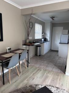 eine Küche und ein Esszimmer mit einem Tisch und einem Kühlschrank in der Unterkunft The Cottage on Alphen in Heathfield