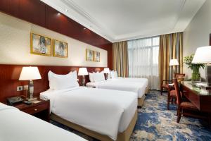 una camera d'albergo con 4 letti e una scrivania di Emaar Royal Hotel a Medina Altre 74 foto