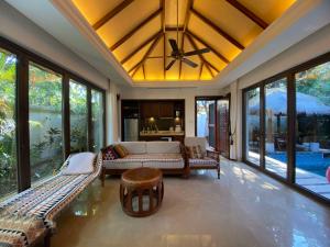 a living room with a couch and chairs and windows at Perfume Bay Tianhai Meiya B&B in Lingshui