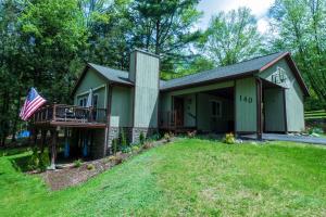 a house with a porch and an american flag at Spacious Catskills Home with Covered Hot Tub in Monticello