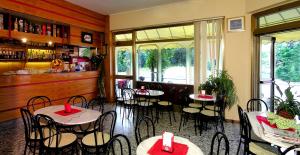 ein Restaurant mit Tischen und Stühlen in einem Zimmer in der Unterkunft Pensione Giardino in Lignano Sabbiadoro