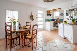 ペズナにあるLa Maison Brocanteのテーブルと椅子のあるキッチンとダイニングルーム