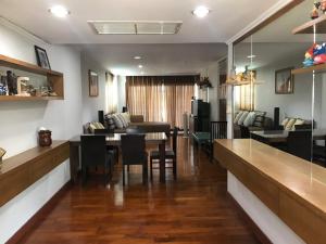 a dining room and living room with a table and chairs at Large beachfront apartment in Cha-am in Ban Bo Khaem