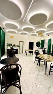 a room with tables and chairs and green curtains at New Green Horse Hotel in Cotonou
