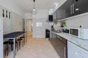 una grande cucina bianca con piano di lavoro ed elettrodomestici di Praceta Living - By Y Concept a Setúbal
