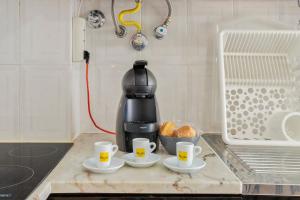 una macchinetta del caffè seduta su un bancone con due tazze di Praceta Living - By Y Concept a Setúbal Altre 15 foto