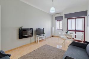 un soggiorno con un divano e una TV a parete di Praceta Living - By Y Concept a Setúbal