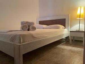 a wooden bed with towels on it in a bedroom at Samothraki Therma Noula Rooms in Samothraki