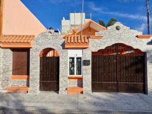 ein Haus mit zwei Toren an einer Straße in der Unterkunft Casa para 18 personas con AC, cocina y a 10 min de la Playa in Playa del Carmen