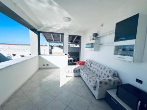 a living room with a couch and a large window at Casa Nadiia in Cinisi