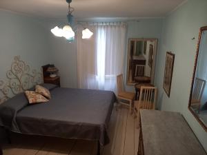 a bedroom with a bed and a chair and a mirror at Casa Deanna in Querceta
