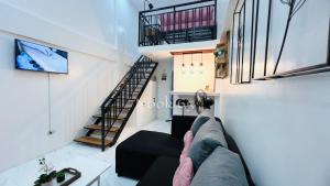 a person sitting on a couch in a living room at 2 Beds Spacious Centrally Located Loft Apartment in Naga