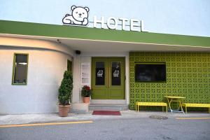 首尔Rio Hotel的一家有绿色门和泰迪熊标志的酒店