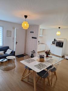 a living room with a white table and chairs at Chez Léonie in Sainte-Mère-Église