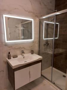 a bathroom with a sink and a shower with a mirror at Hal Wardija Resort Apartments in Qala +14 photos