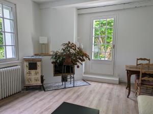 an empty living room with a table and a piano at LES VOLETS BLEUS in Metz