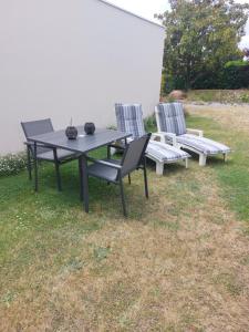 a picnic table and two chairs in the grass at Charmant studio tout équipé in Les Sorinières +1 photo