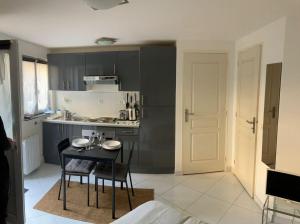 a kitchen with a table and chairs in a room at La cabine des docks in Le Havre