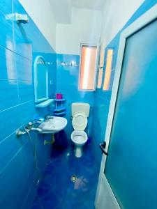 a blue bathroom with a toilet and a sink at Vila Brahimasi in Durrës +17 photos
