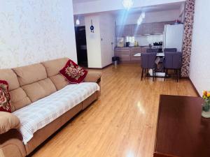 Una sala de estar con un sofá y una mesa y una cocina. en Crown apartment 3 room, en Ulán Bator