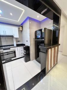a kitchen with black and white appliances in a room at Comfy 2-Bedrooms Apartment in Cairo Sheraton airport in Cairo