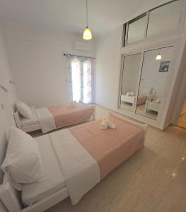 a bedroom with two beds and a living room at Mami in Malia